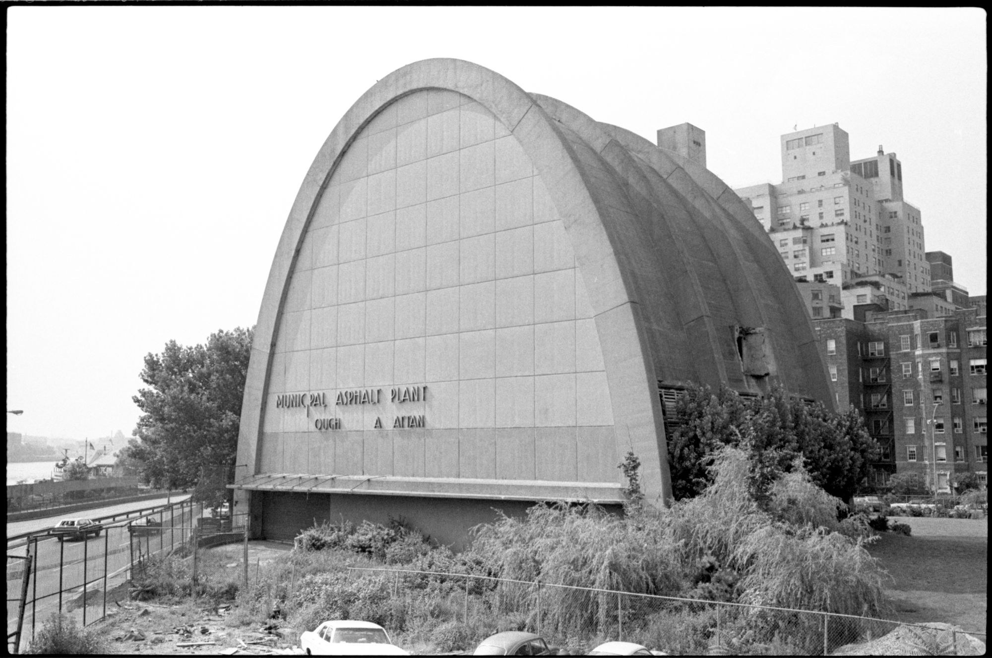 Archival image of a building labeled Municipal Asphalt Plant. Its structure its based around a parabolic curve, arcing from wall to wall.