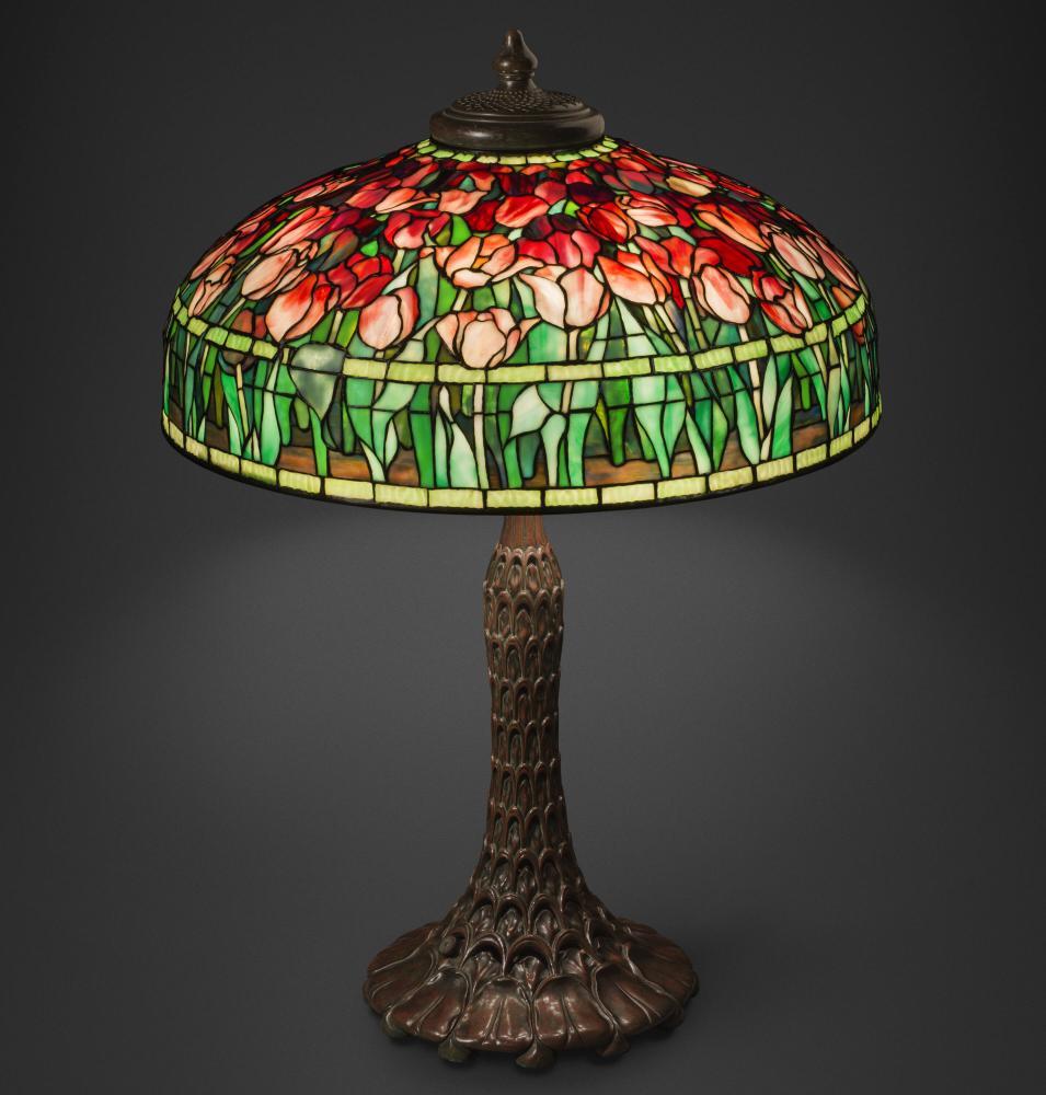 An ornate stained glass table lamp features a shade covered in blooming tulips.