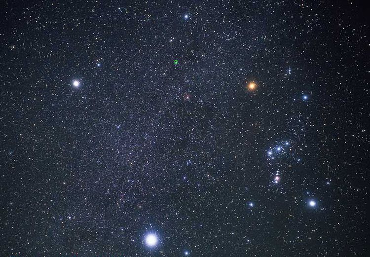 Field of stars in the night sky. The three brightest form a triangle to the left of the constellation Orion.